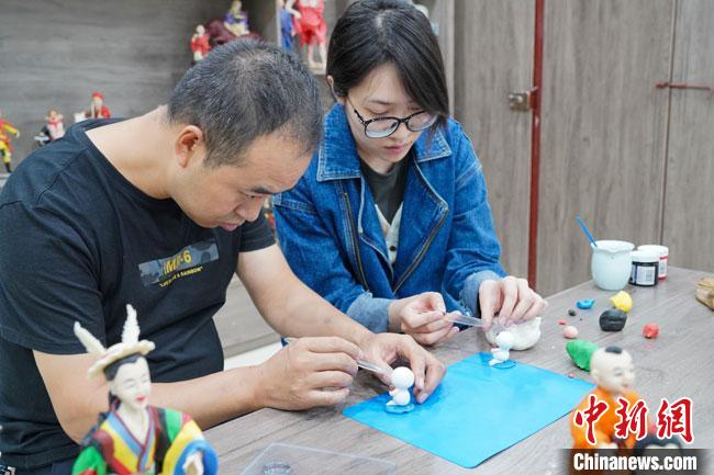 <a target='_blank'  data-cke-saved- >中新社</a>記者(右)現(xiàn)場體驗面塑制作過程?！￡悹帍?攝