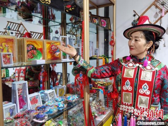 圖為身著民族服飾的隴原巧手展示手工藝品。(資料圖) 徐雪 攝
