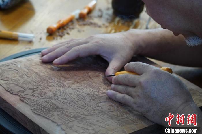 圖為徐晉林湊近木板，近距離制作雕版畫。　九美旦增 　攝