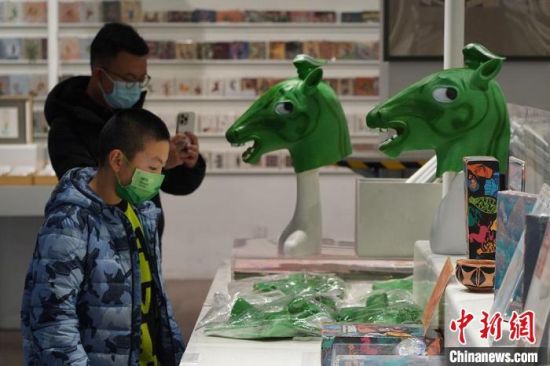 圖為“神馬來了”銅奔馬頭套吸引參觀者駐足。　九美旦增 攝