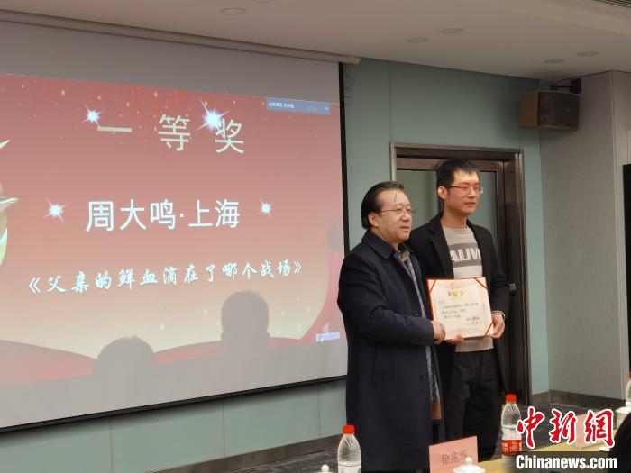 圖為作家、西北師范大學新聞與傳媒學院院長徐兆壽頒發(fā)一等獎證書，代領(lǐng)獎?wù)呱吓_領(lǐng)獎?！钅?攝