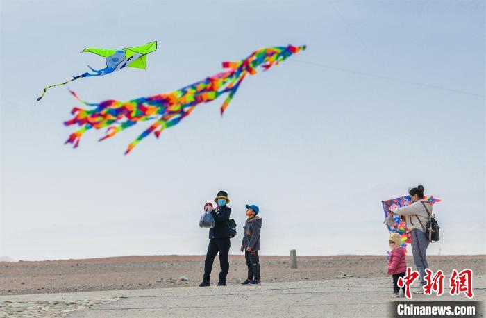 圖為孩童在父母的陪伴下放風(fēng)箏。　王斌銀 攝