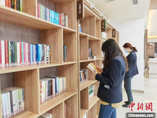 圖為在甘肅公航旅建設(shè)集團(tuán)有限公司的職工書屋，職工挑選書籍?！⌒煅?攝