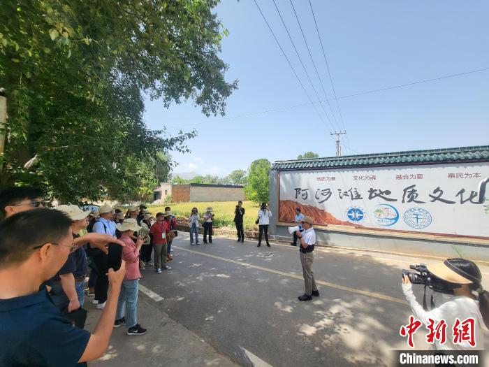 圖為中國地質(zhì)大學(北京)教授張緒教介紹村落情況?！『衍?攝