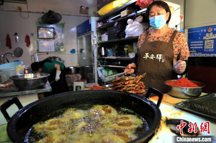 圖為平安驛·河湟民俗文化體驗地內的商戶炸干板魚?！⊙Φ?攝