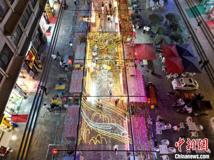 圖為明清街夜市燈光點亮具有武威文化元素的“天梯山石窟”彩燈。(無人機照片) 　戴文昌 攝</p><p>