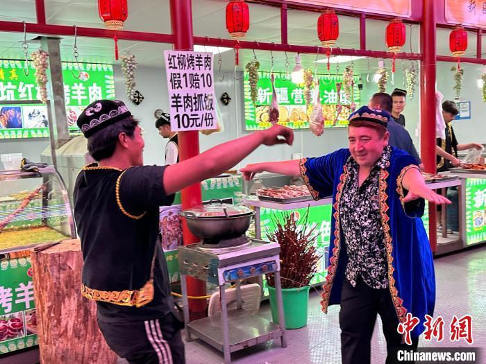 圖為餐飲經(jīng)營者在“西涼不夜城”跳起舞蹈引客。　戴文昌 攝</p><p>