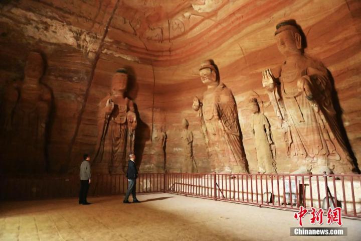 7月15日，游人參觀甘肅省平?jīng)鍪袥艽h百里石窟長廊中的南石窟寺1號窟。百里石窟長廊位于涇川縣境內(nèi)，由512個石窟、5眼窟中石井組成，現(xiàn)存王母宮石窟、鳳凰山石窟、南石窟寺、丈八寺石窟、羅漢洞石窟、太山寺石窟等規(guī)模較大的石窟群，還有數(shù)量眾多的小石窟群。南石窟寺開鑿于北魏永平三年，其中1號窟屬于大型七佛窟，七佛高達(dá)6米。中新社記者 李亞龍 攝